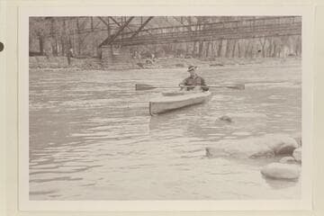 Harold H. Leich in his folding kayak "Rob Roy". Leaving Glenwood Springs after staying the weekend in Glenwood Hotel. Leich left the following Monday at 10:30 am and passed under the railroad bridge. He had started from Grand Lake July 21, 1933