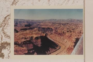 Down Cataract Canyon from the mouth of the Green River. The Henry Mts. are on the skyline. The Land of Standing Rocks is right and Spanish Bottom is center