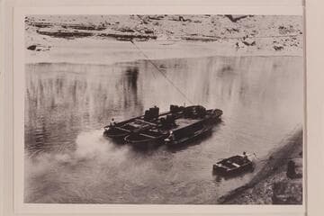 Moving the barge used for the drilling equipment at the lower damsite near Mile 40 in Marble Canyon. The boat near shore is a 16-ft. Smithcraft. Copy of print in Rod Sanderson collection