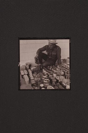 Bill Belknap checks the supplies at Boulder City before taking them to Lees Ferry and other points. Outboard motor traverse of the Grand Canyon