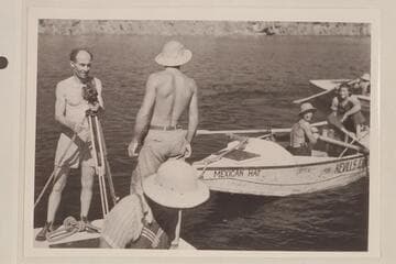 The first trip of Nevills through Grand Canyon; Lake Mead. Emery Kolb at left; Elzada Clover, lower front; Lorin Bell at the oars of the "Mexican Hat"; Lois Jotter sits on stern