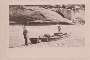 Skiff of Lasky party in small rapid just below Hite. Jesse Lasky, Jr., and Kenneth Wortley